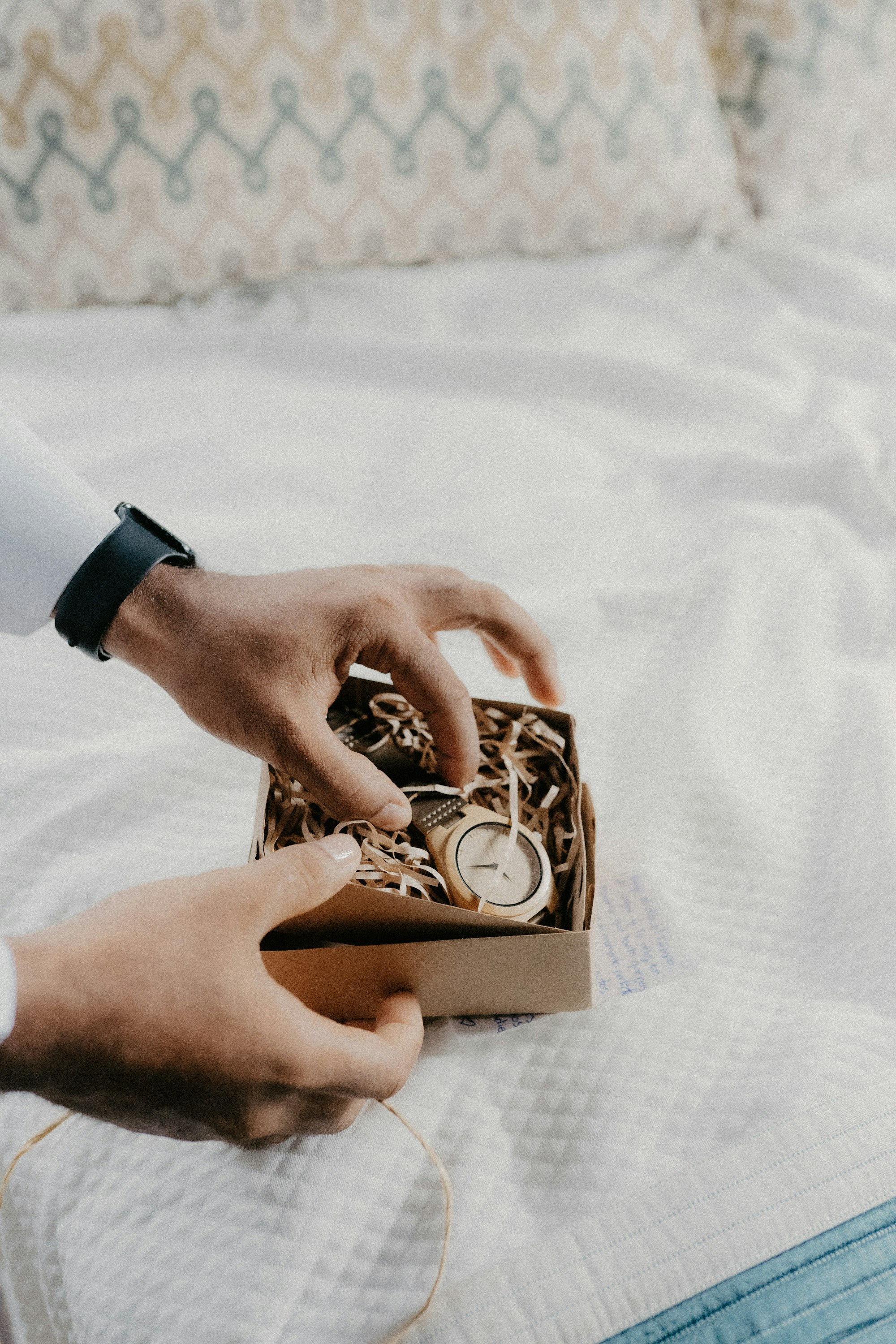 Hands opening a small gift box wrapped in tissue